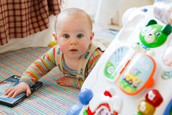 Baby playing with toys and cardboard book