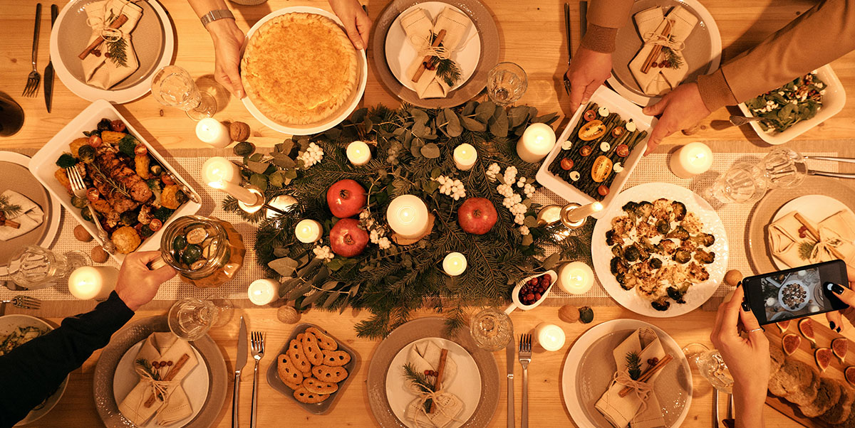 Family Sharing a Holiday meal, Hands Reaching for Food, Taking Photo of Meal with Cellphone | Pexels