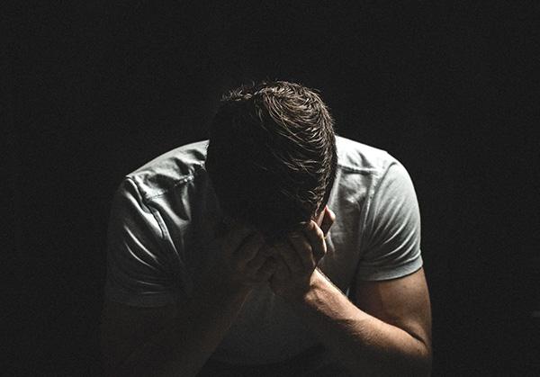 Sad, stressed man hangs his head