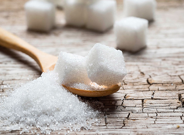Added sugar on a spoon, stacked sugar cubes, diabetes