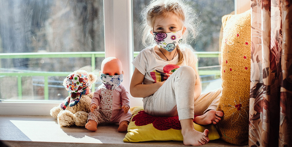 Little girl in face masks with her masked toys