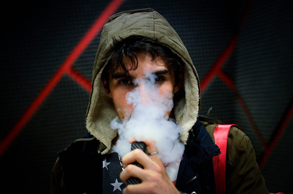Teen boy vaping; photo by Nery Zarate on Unsplash - E-cigarettes and COVID-19