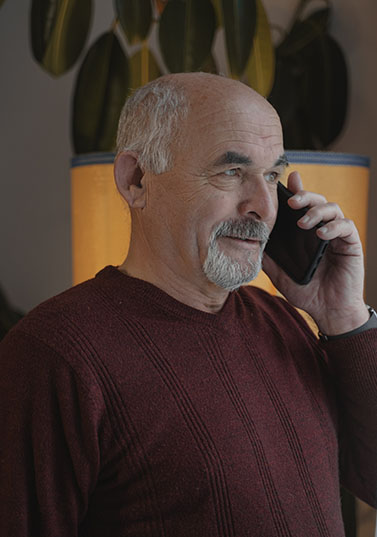 A male patient in hid late 60s receiving phone call from Laurel Health clinic