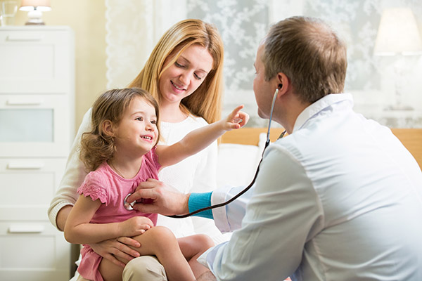 Smiling Child on Mother's Lap Reaching for Pediatrician