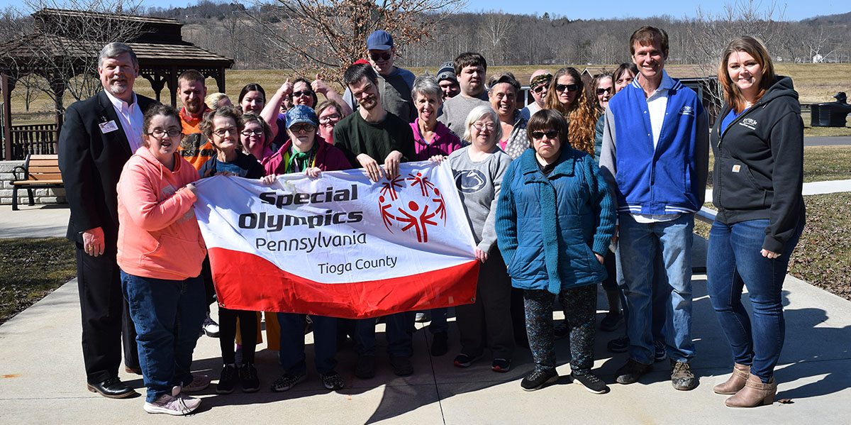 James A. Nobles, President and CEO of the Laurel Health Centers (pictured on the left), Kevin Thomas, KC101 Station Owner, and Jess Sandstrom, KC101 General Manager (pictured on the right), present the donation to Special Olympics athletes and staff at Partners in Progress in Mansfield, PA