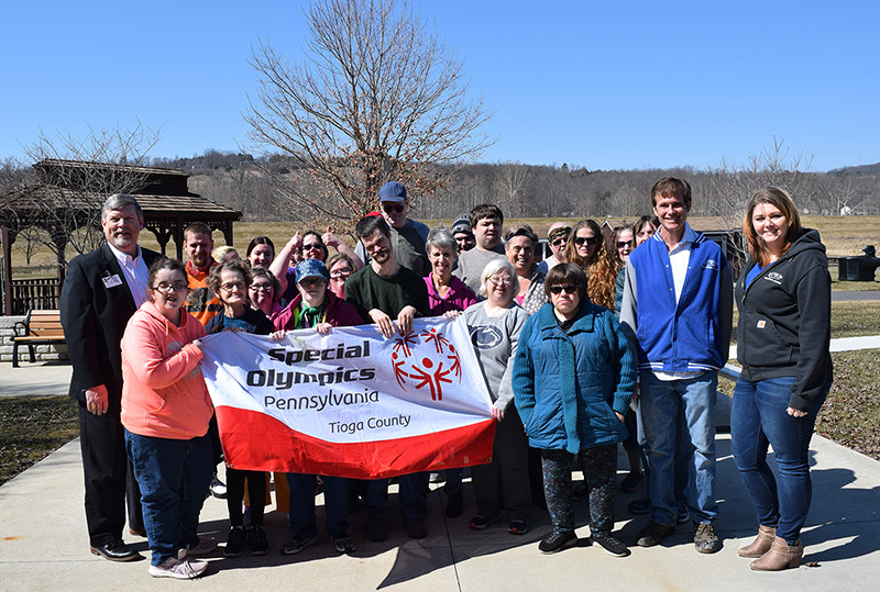 James A. Nobles, President and CEO of the Laurel Health Centers (pictured on the left), Kevin Thomas, KC101 Station Owner, and Jess Sandstrom, KC101 General Manager (pictured on the right), present the donation to Special Olympics athletes and staff at Partners in Progress in Mansfield, PA