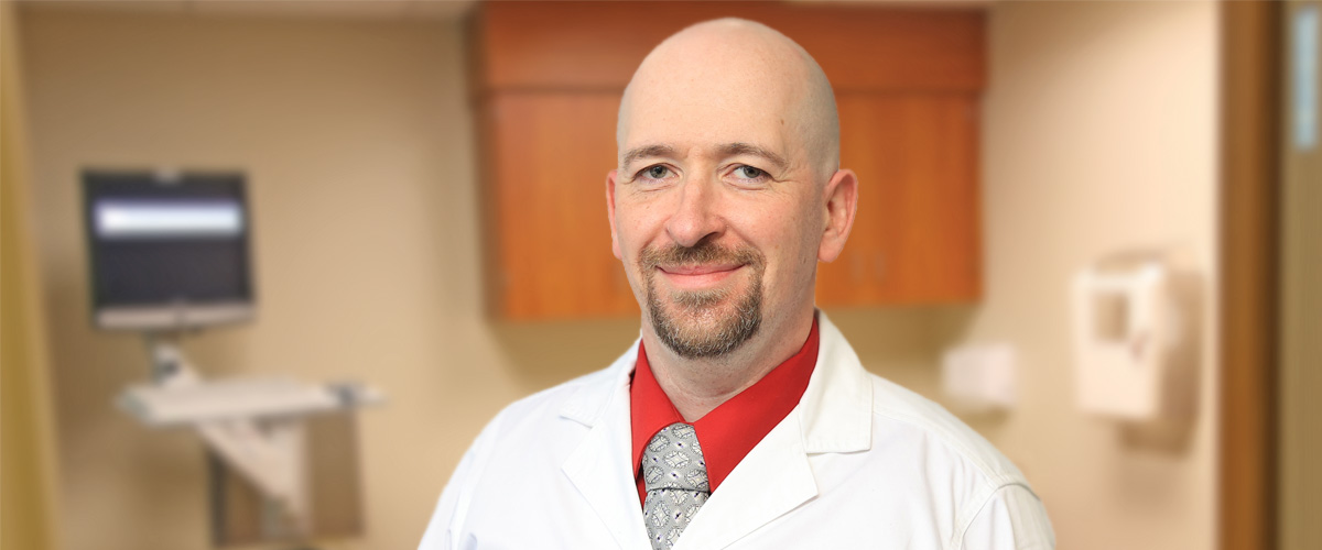 Photo of Daniel Branzburg, CRNP in a white coat in an exam room, certified registered nurse practitioner who now provides family medicine healthcare at Troy Laurel Health Center, located at 45 Mud Creek in Troy, PA