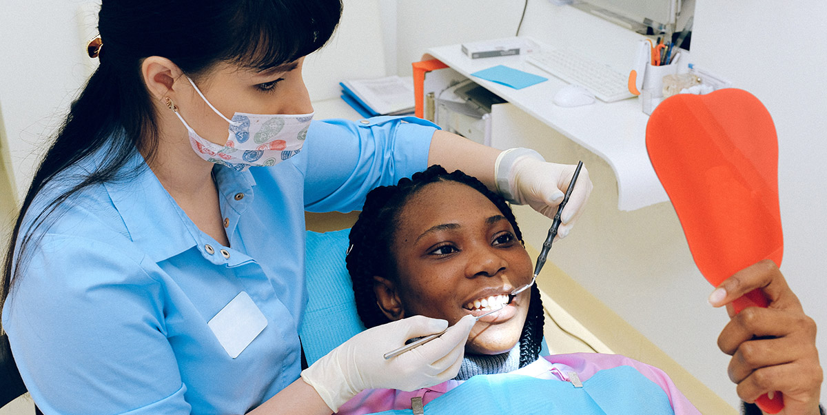 Dental Hygienist Working with a Smiling Patient - Laurel Health is Sponsoring Local Students Who Want to Become Dental Hygienists