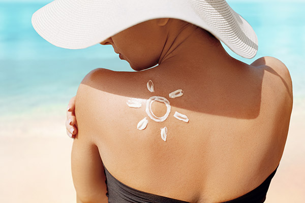 Woman with sunscreen in the shape of a sun on her shoulder