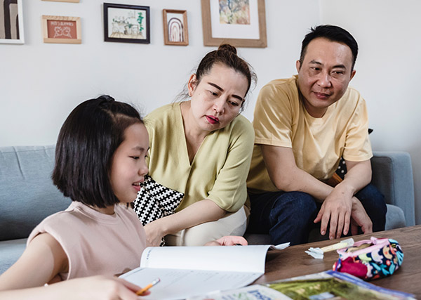 Asian family discussing their emergency preparedness plan at the living room table