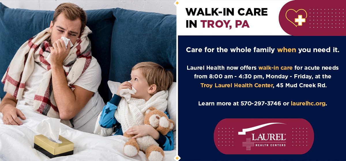Photo of father and son with colds in bed blowing their noses, ready to visit Troy Laurel Health Center’s new walk-in care service in Troy, PA
