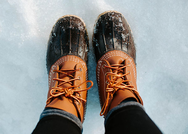 Wearing snow boots and snow pants to protect from the cold and snow | Leah Kelley (Pexels)